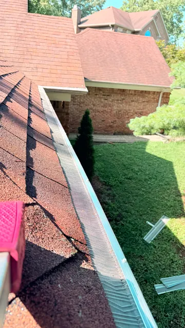 Gutter guard beside a metal roof